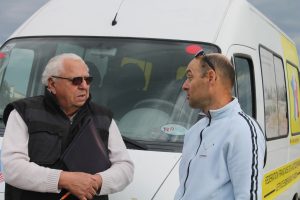Le président de la FFCBL/SER discute avec une autre personne devant le camion de la fédération.