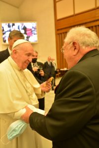 Le président de la FFCBL/SER tenant le bras du Pape François lors de la réception au Vatican à Rome, le 26 mars 2022.