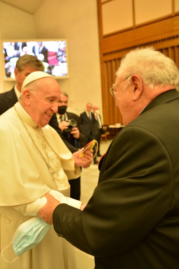Le président de la FFCBL/SER tenant le bras du Pape François lors de la réception au Vatican à Rome, le 26 mars 2022.