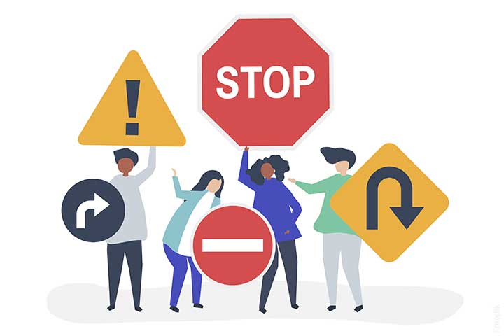 Image d'illustration: des personnes tenant des panneaux(stop, sens interdit ...)