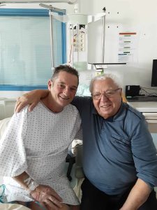 André Antonio, président de la FFCBL/SER, et Erik, assis côte à côte lors d’une visite à l’hôpital, partageant un moment d’amitié et de soutien.